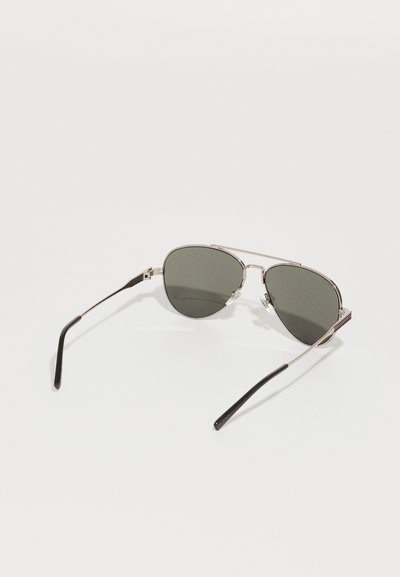 Metal aviator sunglasses with dark gray lenses, thin silver frames, and black plastic tips on the arms. Sleek, minimalist design.