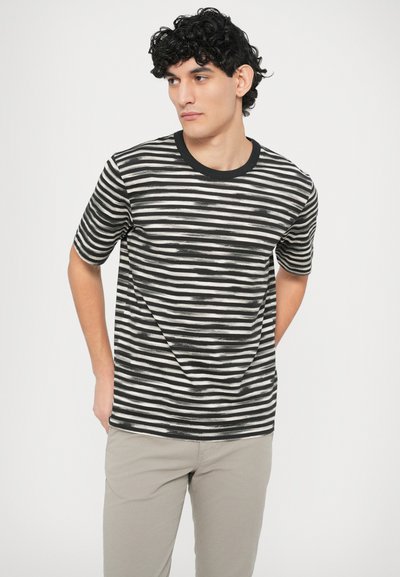 Svītraina melna un balta T-krekla ar apaļu kakla izgriezumu. Īsas piedurknes un brīva piegriezuma, izceļot teksturētu auduma rakstu.