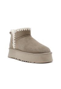 Suède enkellaars in taupe met een textuur platformzool. Voorzien van een decoratieve witte, gegolfde rand rond de enkel en een ronde neus.