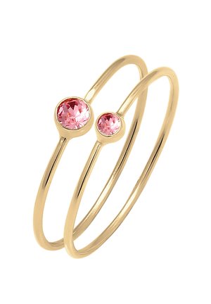 To tynde gyldne ringe, hver sat med en rund lyserød ædelsten, en større og en mindre, vist mod en hvid baggrund.