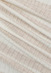 Texturiertes Gewebe in zartem Rosa und Weiß, mit abwechselnden Streifen und kleinen dekorativen Ösenmustern, die in überlappenden Lagen angeordnet sind.