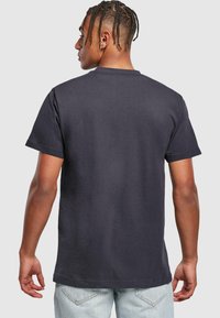 Mørkeblå kortærmet T-shirt lavet af bomuld, med rund hals og afslappet pasform, har en glat tekstur og minimalistisk design.