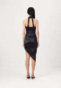 Crna satenska halter haljina s uskim korzetom, otvorenim leđima i asimetričnom rubom. Glatka tekstura s elegantnom siluetom.