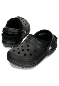 Schwarze Clogs aus leichtem Material, mit einem kuscheligen Innenfutter, Belüftungsöffnungen und einem Fersenriemen für einen sicheren Sitz. Strukturierte Sohle.