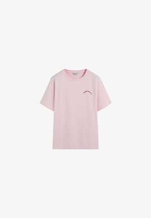 Roze katoenen t-shirt met korte mouwen, ronde hals, en kleine rode tekstlogo gedrukt op de bovenste linkerkant van de voorkant. Vloeiende textuur, ontspannen pasvorm.