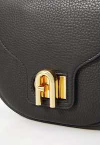 Borsa a tracolla in pelle nera con texture, caratterizzata da una chiusura dorata e dettagli in metallo rettangolari. Finitura liscia con una grana visibile.