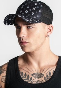 Gorra negra con logos blancos estampados, parte trasera de malla, visera curva y acabado texturizado. Cuenta con correa ajustable en la parte trasera.