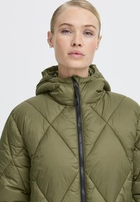 Olijfgroene, gewatteerde pufferjack met capuchon, voorzien van een ritssluiting aan de voorkant en een ruitpatroon.