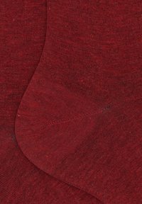 Un paio di calzini in cotone di un oscuro rosso uniforme con una texture a maglia fine, mostrano le dita e i talloni sovrapposti.