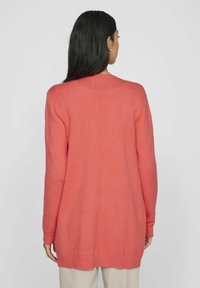 Korallfarbener Cardigan mit langen Ärmeln, der über einen gerippten Halsausschnitt und Bündchen verfügt, eine weiche Textur hat und eine lockere Passform aufweist, die unter die Hüften reicht.