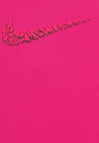 Tejido de un rosa brillante con una superficie texturizada que presenta un logo de swoosh de Nike en negro y rosa en la parte superior. Diseño simple y audaz.