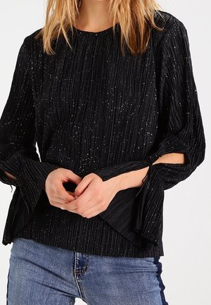 Top negro con pliegues y destellos plateados, con mangas acampanadas y cierres de lazo. Hecho de una tela texturada, perfecto para un look casual.