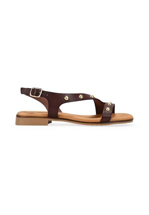 Sandalia plana de cuero marrón con correa ajustable de hebilla y tachuelas metálicas doradas, plantilla acolchada color marrón claro y tacón bajo de bloque.