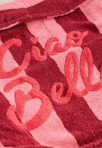 Towel featuring alternating stripes of red and pink, with textured embroidery spelling "Ciao Bell" in vibrant pink thread.