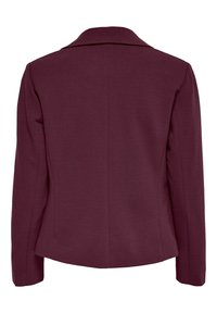 Veste cintrée bordeaux en tissu lisse, dotée d'un col classique et d'une silhouette ajustée avec des manches longues et sans fermetures visibles.