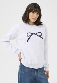 Lichtgrijze sweatshirt met een marineblauwe strikafbeelding op de voorkant. Heeft een ronde hals, lange mouwen en ribgebreide boorden en onderkant.