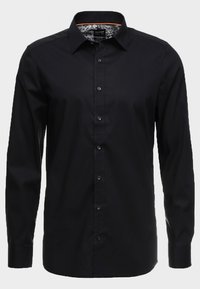 Svart långärmad skjorta av slät tyg, med knäppning fram, spetsig krage och mönstrade insida på manschetterna.