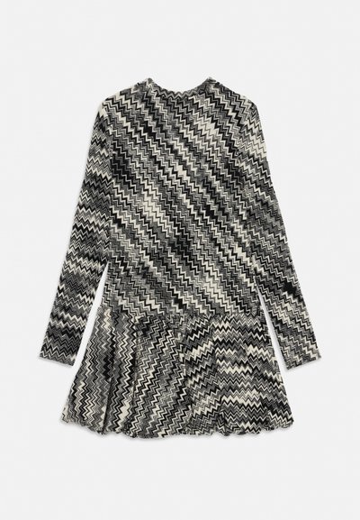 Vestito a maniche lunghe con motivo a zigzag bianco e nero, scollo tondo e gonna svasata.