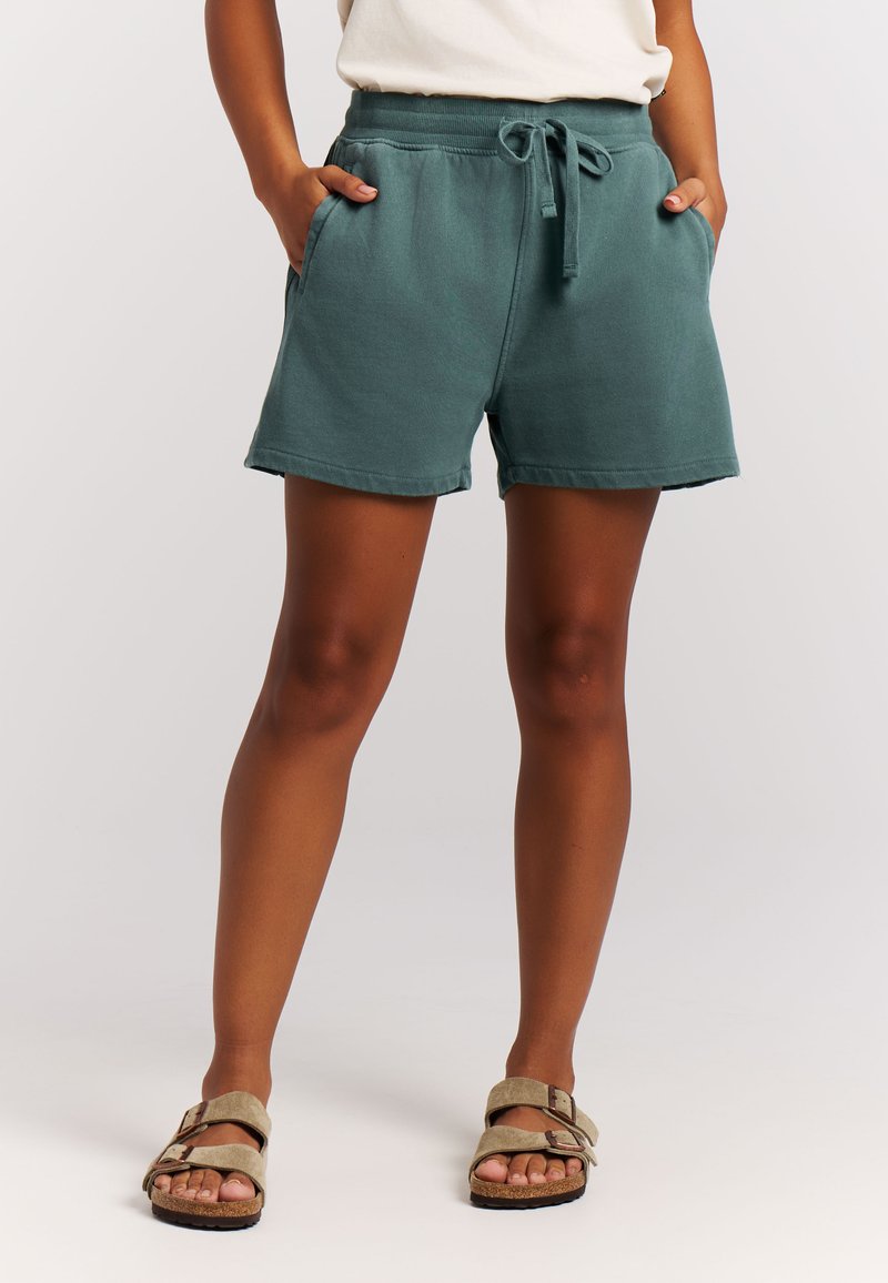 Shorts en coton turquoise avec une taille élastique, un cordon de serrage et des poches latérales, présentant une coupe décontractée et un ourlet cousu.