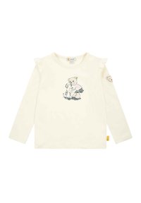 Camicia a maniche lunghe color crema con dettagli arricciati sulle spalle. Presenta un design stampato di un orso e un cane. Include un patch a forma di orso sulla manica.