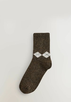 Calcetín marrón acanalado con patrón de diamantes blancos y textura moteada. Presenta una puntera y un puño reforzados. Diseño estándar de longitud de tobillo.