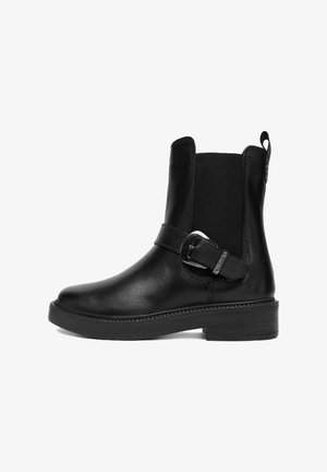 Czarny skórzany botek za kostkę z niskim obcasem, elastycznym panelem bocznym, ozdobnym paskiem i metalową klamrą na białym tle.