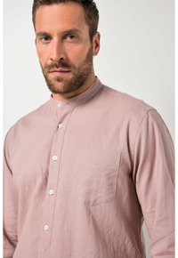 Hellrosa langärmliges Hemd mit Stehkragen, durchgehender Knopfleiste, einer Brusttasche und strukturierter Stoff.