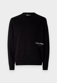Black sweatshirt made of soft fabric, featuring a crew neck design. "Calvin Klein" logo printed in white on the lower left side.