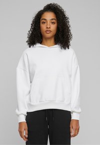 Weißer Kapuzenpullover mit frontaler Tasche, eingesetzten Schultern und gerippten Bündchen. Glatte Stoffstruktur, lockere Passform.