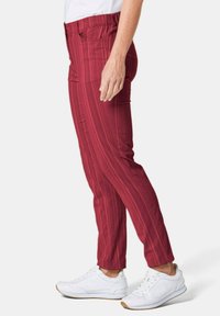 Rood gestreepte broek met een slim fit, gemaakt van een zachte stof, met een elastische tailleband en voorzakken, gecombineerd met witte sneakers.