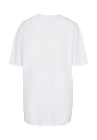 Camiseta de algodón blanca con mangas cortas, escote redondo y un corte relajado. Sin patrones ni acentos visibles en la parte trasera.