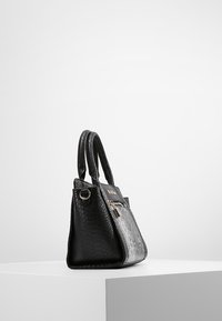 Svart handväska med en strukturerad yta i krokodilsmönster, utrustad med dubbla handtag, dragkedjestängning och detaljer i guldton.