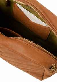 Brown leather handbag with quilted texture, gold zipper, and green interior lining. Features card pocket and metallic hardware accents.