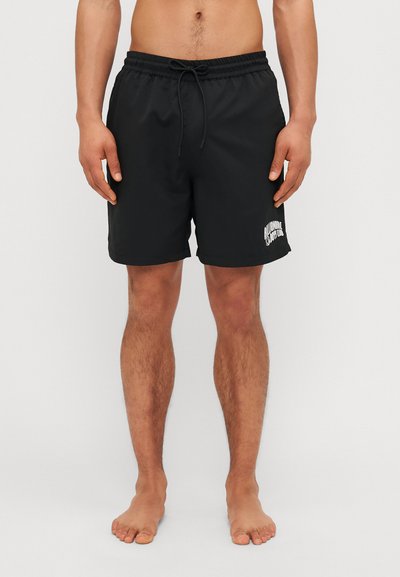 Schwarze Badeshorts aus leichtem Stoff, mit elastischem Bund und Kordelzug, und einem weißen Logo, das am unteren linken Bein aufgedruckt ist.