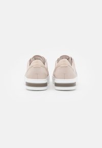 Light pink suede slip-on shoes with a white sole and brown accent on the heel, featuring a smooth texture and clean lines.
