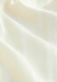Tissu de crème clair avec de subtiles rayures verticales, texture lisse et composition légère. Idéal pour diverses applications textiles.