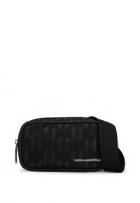 Črna pravokotna torbica čez ramo z reliefnim geometričnim vzorcem, zapiranjem na zadrgo, širokim nastavljivim trakom in kovinsko nalepko "KARL LAGERFELD" na sprednji strani.