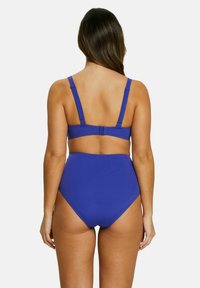 Bikini deux pièces de couleur violet uni. Le haut dispose de bretelles réglables et d'une fermeture à clip. Le bas taille haute offre une couverture complète.