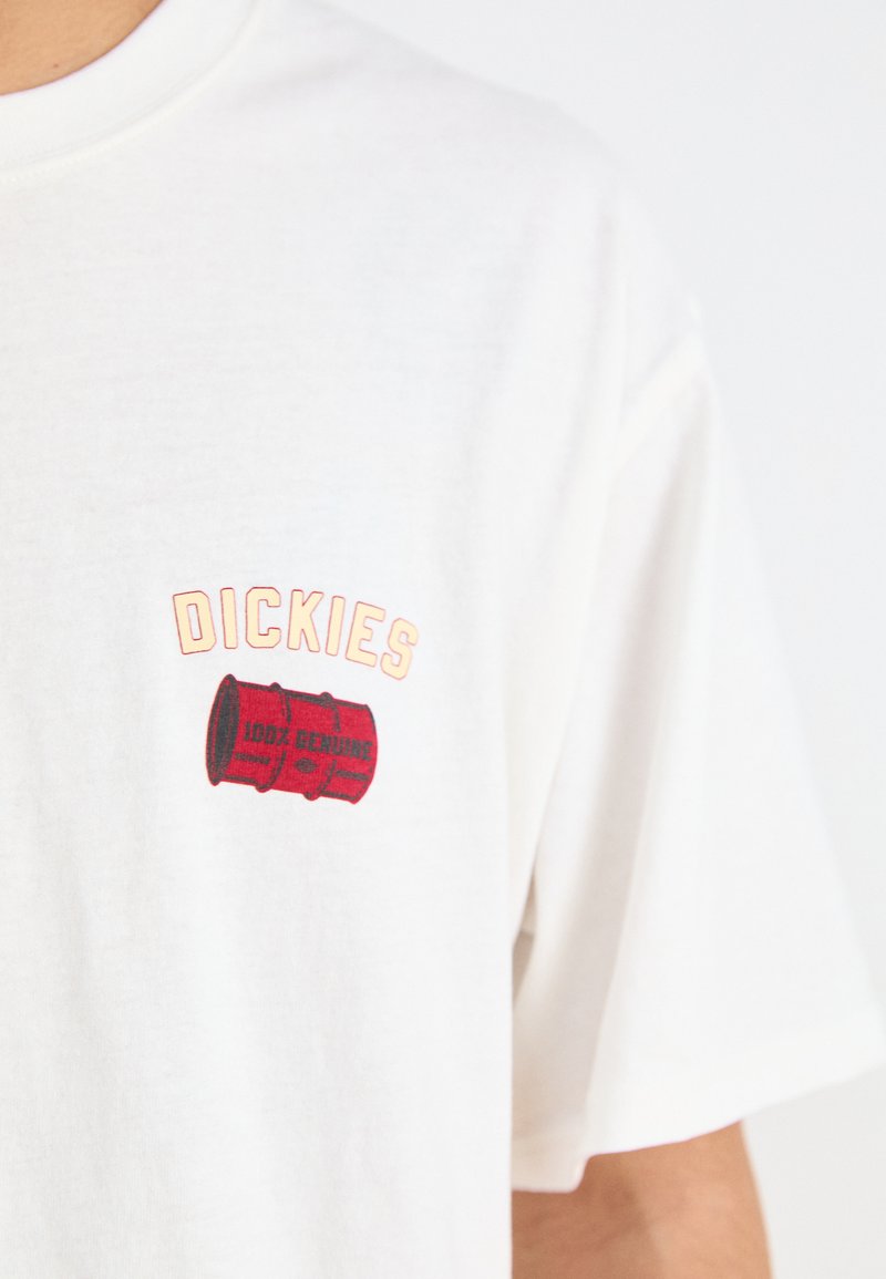Biała bawełniana koszulka z krótkim rękawem z czerwonym nadrukiem przedstawiającym beczkę i napisem "DICKIES 100% GENUINE". Luźny krój.