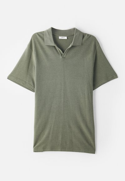 Polo shirt vert olive à manches courtes avec un col et un tissu texturé. Présente une ouverture en forme de V et une coupe décontractée.