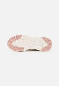 Semelle de chaussure en caoutchouc avec un design texturé crème et rose pâle, présentant des motifs géométriques et des éléments d'adhérence pour une meilleure traction.