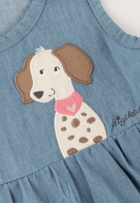 Jeanskleid mit einem gestickten Hundedesign mit braunen Flecken, einem rosa Kragen und einem Herzdetail. Hellblaues Gewebe mit plissiertem Rock.
