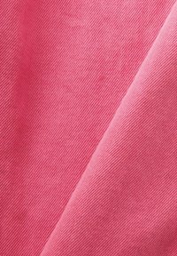 Tejido texturizado en un vibrante tono rosa, con un patrón de tejido diagonal de tonos contrastantes, que resalta su superficie suave.
