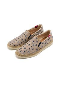 Zapatos beiges sin cordones con patrones en azul marino, fabricados en tejido texturizado. Presentan una suela intermedia de yute y acentos laterales en contraste.