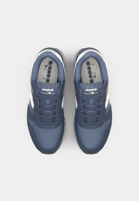 Navy blue sneakers with a mesh and synthetic upper, white accents, round toe, and a textured sole. Features a lace-up design and logo detailing.