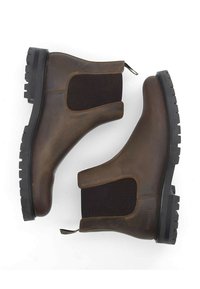 Bottines Chelsea en cuir marron avec des panneaux latéraux élastiques, semelles en caoutchouc noir robuste et une boucle pour un enfilage facile. Texture lisse avec des détails subtils.