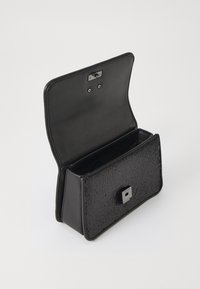 Borsa nera con un pannello frontale testurizzato, dettagli in pelle, una chiusura magnetica quadrata e un scomparto aperto all'interno.