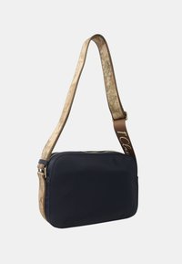 Borsa a tracolla in tessuto blu navy con una tracolla beige a motivi, progettata con chiusura con zip e forma rettangolare per un facile accesso.