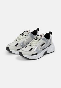 Sneaker a rete bianche e argento con dettagli neri, punta rotonda, colletto imbottito e suola testurizzata. Presenta un logo ben visibile sui lati.