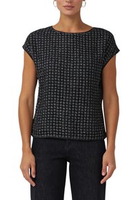 Czarny top z krótkim rękawem o fakturowanym wzorze w kratę, wykonany z miękkiej tkaniny. Luźny krój i okrągły dekolt. Połączony z ciemnymi jeansami.